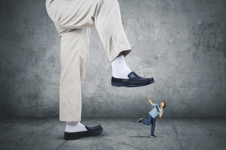 Picture of scared African man wearing sportswear while running from his boss footの写真素材