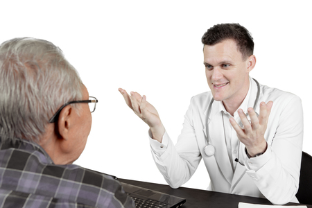 Picture of European doctor talking with elderly male patient and sitting in the studio, isolated on white backgroundの写真素材