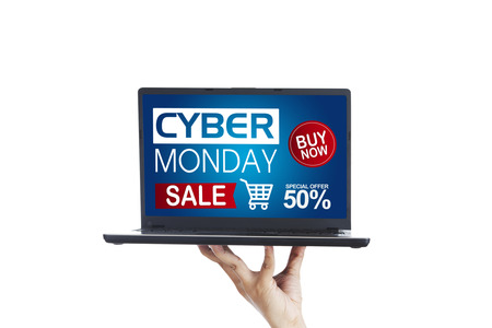 Picture of unknown person's hand showing a computer laptop with Cyber Monday Sale text, isolated on white backgroundの写真素材