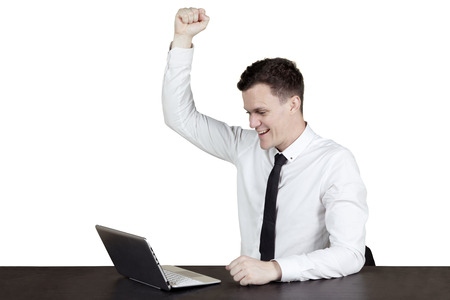 Portrait of successful Caucasian worker expressing his success while looking at the computer on the tableの写真素材