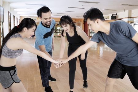Picture of diversity people joining their hands before doing a workout in the fitness centerの写真素材