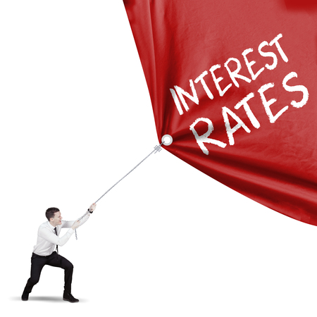 American male entrepreneur pulling a red fabric with text of interest rates, isolated on white backgroundの写真素材