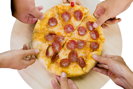 Top view of hands taking pepperoni pizza slices from wooden plateの写真素材