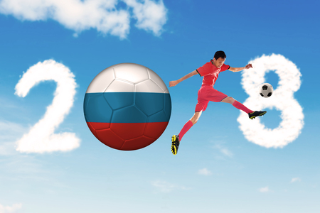 Male soccer player kicks a Russia soccer ball with 2018 numbersの写真素材