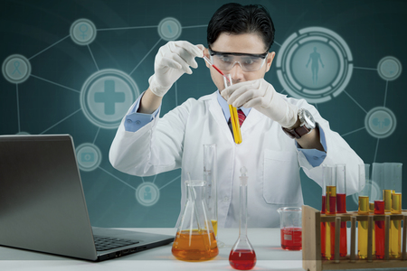 Male scientist doing chemical research with futuristic backgroundの写真素材