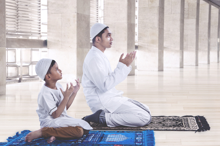 Muslim father and son praying together in a mosqueの写真素材