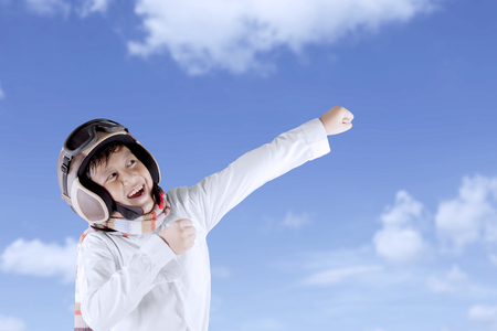 Funny Asian boy wearing vintage pilot helmet posing isolated over white backgroundの写真素材