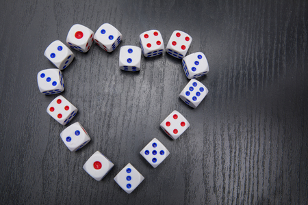 Top view of white dices shaped a symbol of heart on the black tableの写真素材