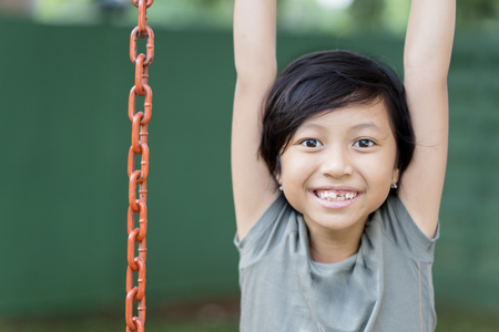 Picture of cute little girl smiling at the camera while playing in the playgroundの写真素材