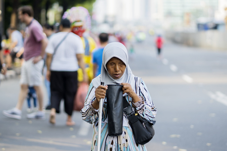 JAKARTA - Indonesia. June 12, 2018: Blinded old female asks for money from passing people along a roadのeditorial素材