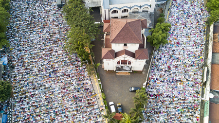 JAKARTA - Indonesia. JUNE 15, 2018: Thousands of muslims praying together on the street during Eid-ul Fitr day near Koinonia Church in East Jakarta, Indonesia.のeditorial素材