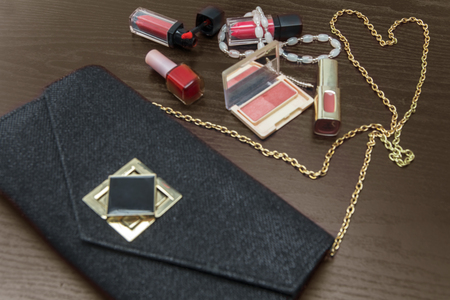 Closeup of female cosmetic bag with makeup tools on the wooden tableの写真素材