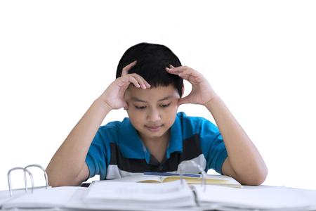 Picture of preteen boy looks stressed while studying in the studio, isolated on white backgroundの写真素材
