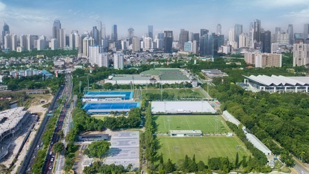 JAKARTA - Indonesia. JULY 24, 2018: Aerial view of Senayan stadium with skyscrapers under blue sky...