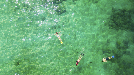 Picture of three tourists snorkeling together in the turquoise water. Shot in Lombok, Indonesiaの写真素材