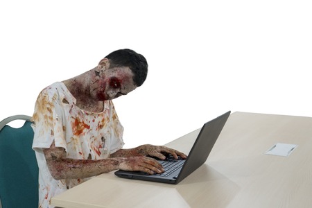 Halloween horror concept. Picture of creepy male zombie is looking at the camera while playing a...