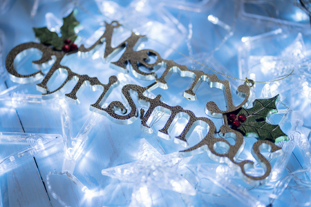 Closeup of Christmas star lights with Merry Christmas text on the wooden tableの写真素材