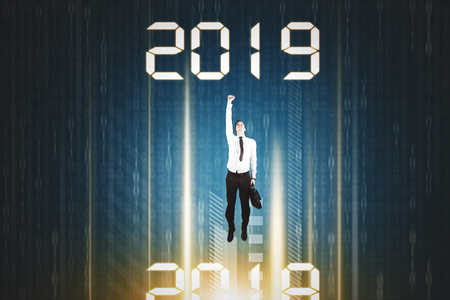 Caucasian businessman flying from number 2018 to number 2019 inside code binaryの写真素材