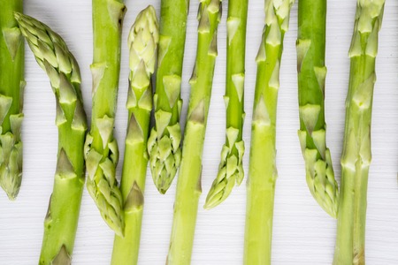 Macro shot of fresh raw sprouts of asparagus on the wooden table. Shot in the studioの写真素材