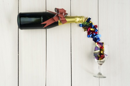 Top view of champagne bottle with glass filled by streamersの写真素材