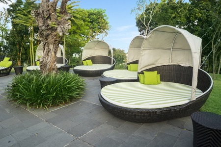 Image of empty large loungers with cushions by the pool in luxury hotelの写真素材