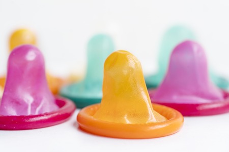 Closeup of many colored condoms on the tableの写真素材