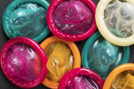 Safe sex concept. Top view of messy colorful condoms over tableの写真素材