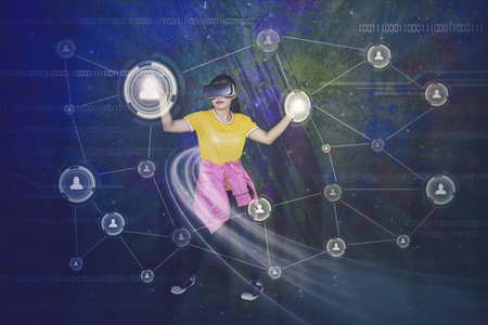 Female dancer wearing virtual reality headset and touching social network button on the virtual...