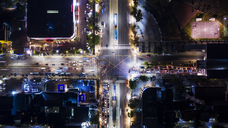 Top view of traffic jam on road junction with crosswalk at night time in Jakarta city