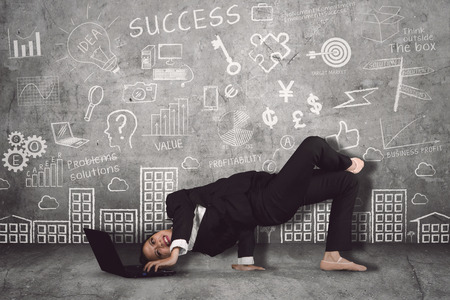 Female ballet dancer wearing suit while working with a laptop in doodles backgroundの写真素材