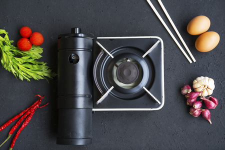 Top view of small stove with eggs, chopstick, and seasoning on the tableの写真素材