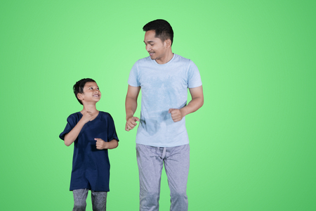 Picture of little boy looks happy while jogging with his father in the studioの写真素材
