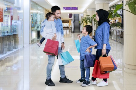 Picture of Muslim family holding shopping bags while talking each other in the mallの写真素材