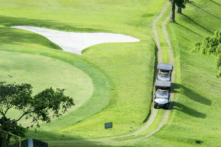 Aerial view of two golf carts parking on the golf courseの写真素材