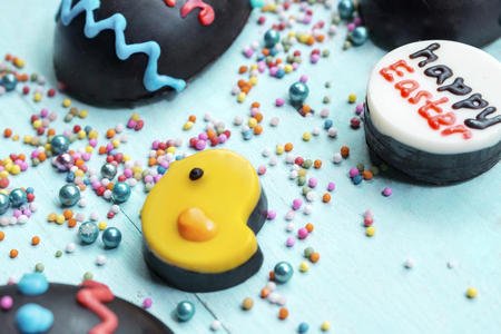 Close up chocolate chick with easter eggs and happy easter text on wooden table