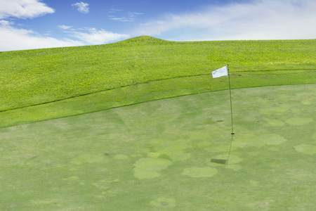 Aerial view of beautiful golf course with white flag under blue sky in Bandung city, West Java, Indonesiaの写真素材