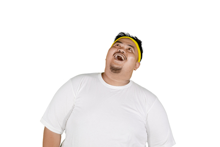 Image of obese man looking up with shocked expression while standing in the studio, isolated on white backgroundの写真素材