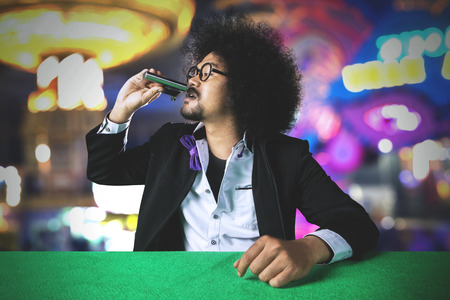 Image of a stress gambler man drinking alcohol after losing a gamble in the casinoの写真素材