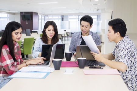 Image of young business team looks busy while working with laptops in the officeの写真素材