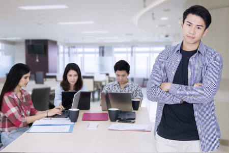 Picture of Asian male business leader looks confident while standing in front of his partners in the officeの写真素材