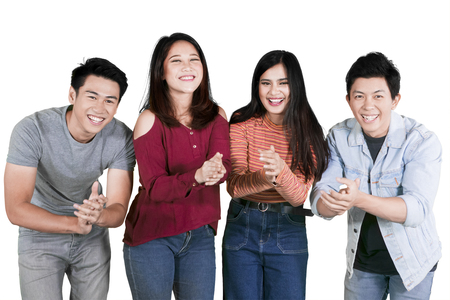 Group of college students looks happy while applauding at the camera, isolated on white backgroundの写真素材