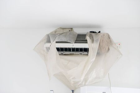 Image of dirty air conditioner blower fan and coil wrapped by plastic during cleaning serviceの写真素材