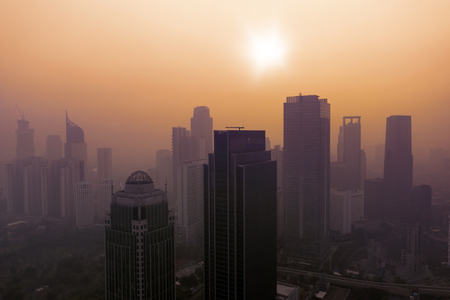 JAKARTA - Indonesia. July 15, 2019: Aerial view of office buildings with dust smog in Jakarta downtown at sunset timeのeditorial素材