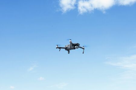 Image of black drone with high resolution digital camera in the blue sky
