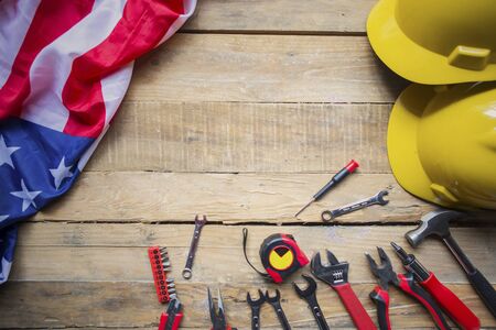 Top view of two helmet with tools and American flag on the wooden table