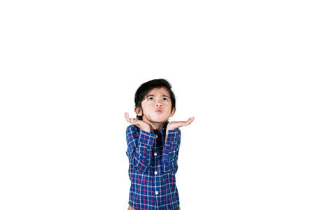 Asian little boy looks confused while standing with lifting arms in the studio, isolated on white