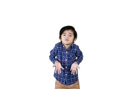 Picture of a little boy expressing confused while standing in the studio, isolated on whiteの写真素材