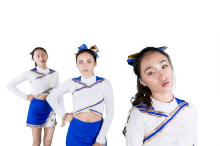 Picture of cheerleading team looking at the camera while standing together in the studio
