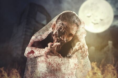 Halloween horror concept. Creepy bride ghost posing near the abandoned house at night time