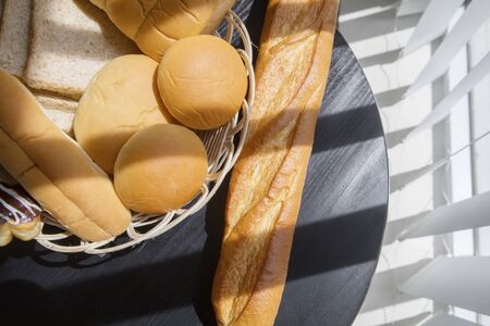 Top view of tasty breads on the wooden table near the window